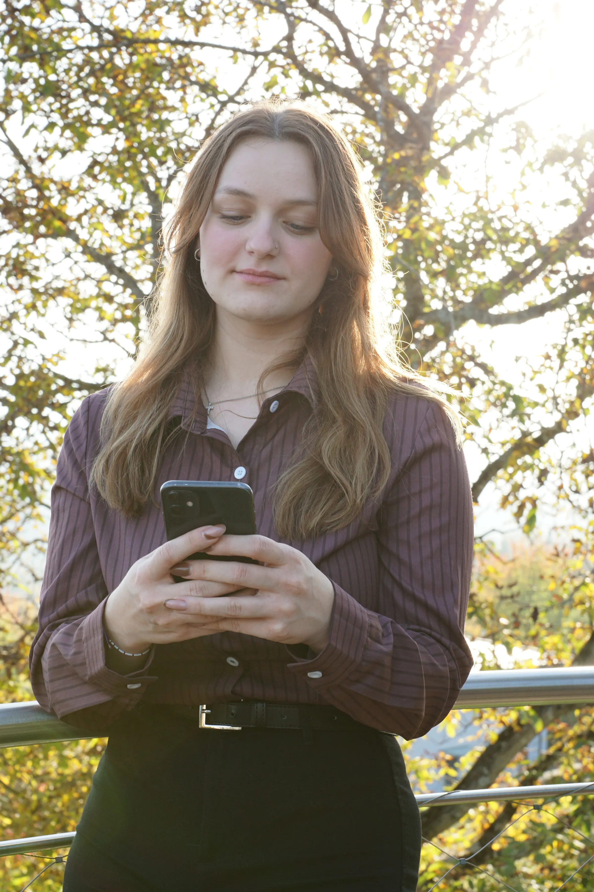 Timea blickt konzentriert auf ihr Handy.